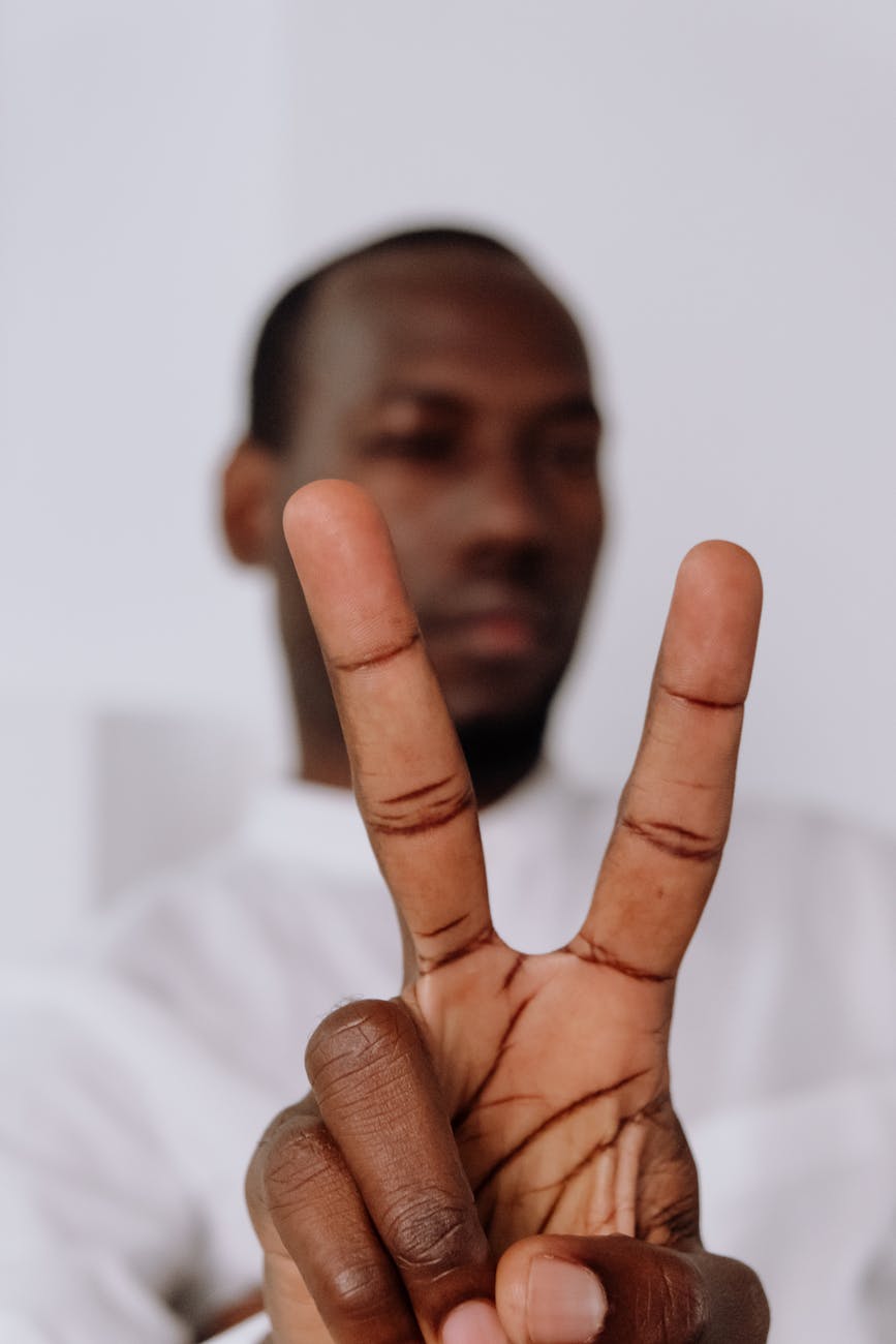 man in white dress shirt showing his middle finger
